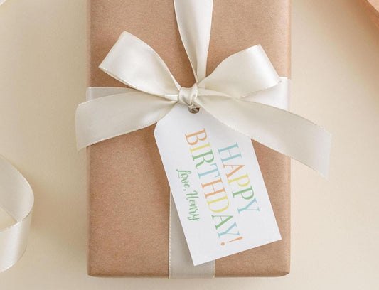 A brown gift box with a white ribbon and a tag that reads "Happy Birthday! Love, Henry".