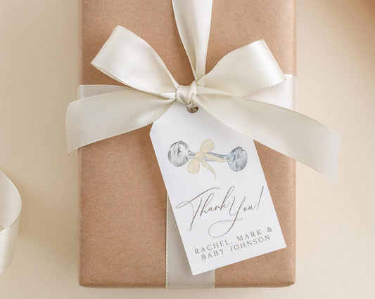 A brown gift box with a white ribbon and a tag attached to it, which says "Thank you! Rachel Mark & Baby Johnson".