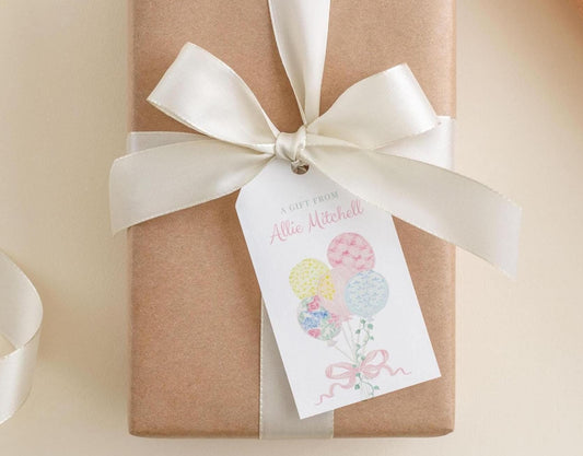 A gift wrapped in brown paper with a white ribbon and a tag that reads "A gift from Allison Mitchell".