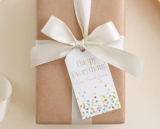 A brown gift box with a white ribbon and a tag that reads "Happy Everything! Love, Sarah James"