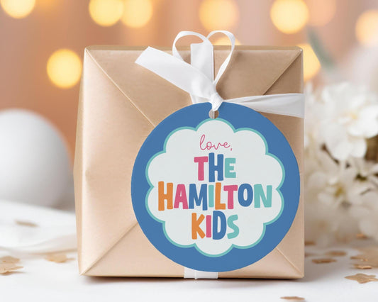 A brown gift box with a blue and white circular tag that says "love, The Hamilton Kids".