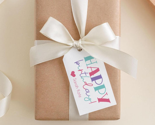 A brown gift box with a white ribbon and a tag that says "Happy Birthday Sarah Kate".