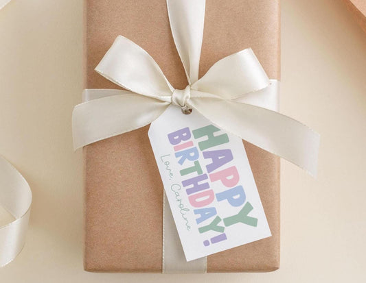 A brown gift box with a white ribbon and a tag that says "Happy Birthday!"