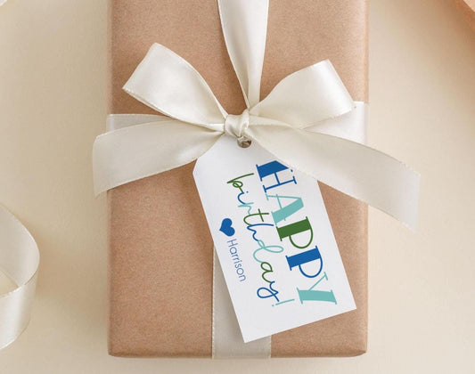 A brown gift box with a white ribbon and a tag that says "Happy Birthday!"