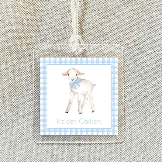 A clear name tag with a picture of a lamb and the name "Holden Carlson" printed on it.