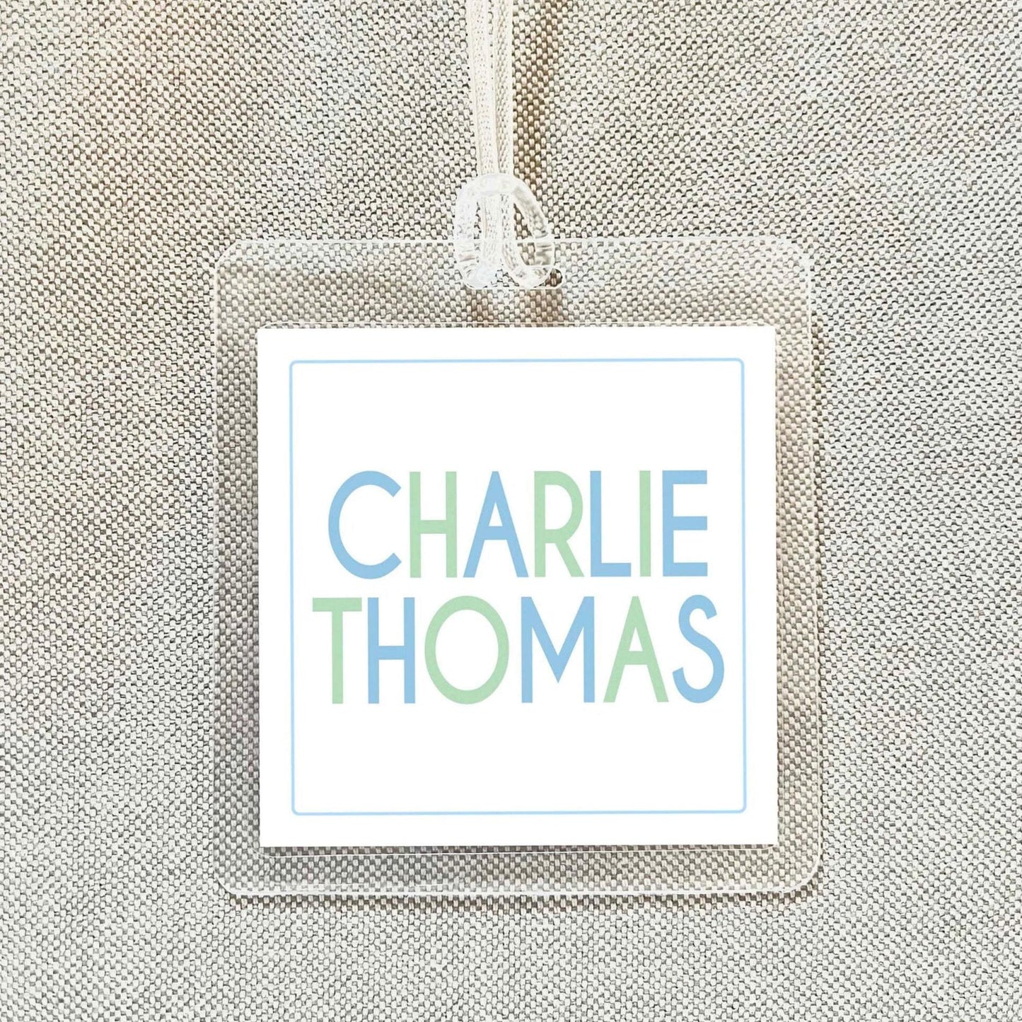 A clear name tag with the name "CHARLIE THOMAS" printed on it.