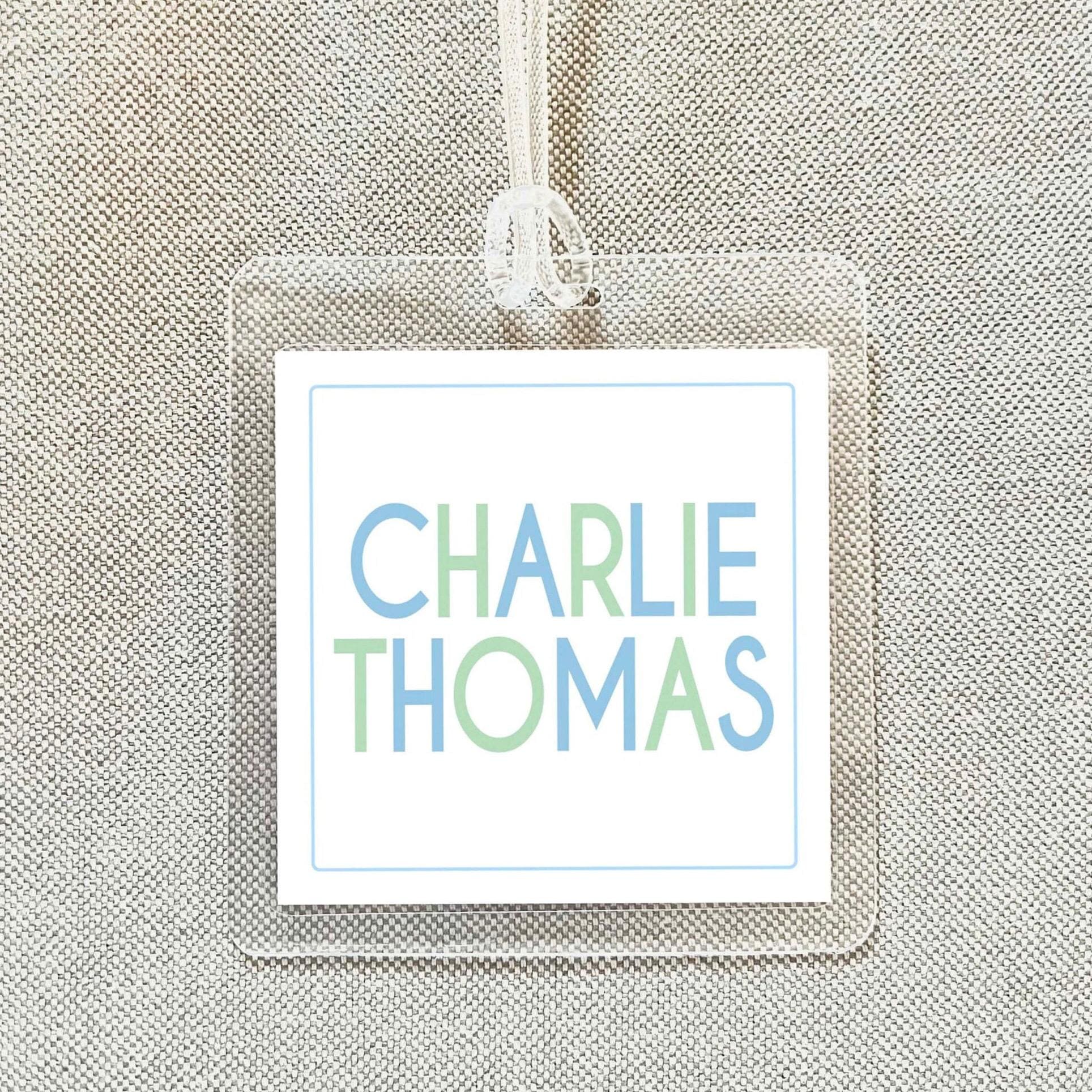 A clear name tag with the name "CHARLIE THOMAS" printed on it.