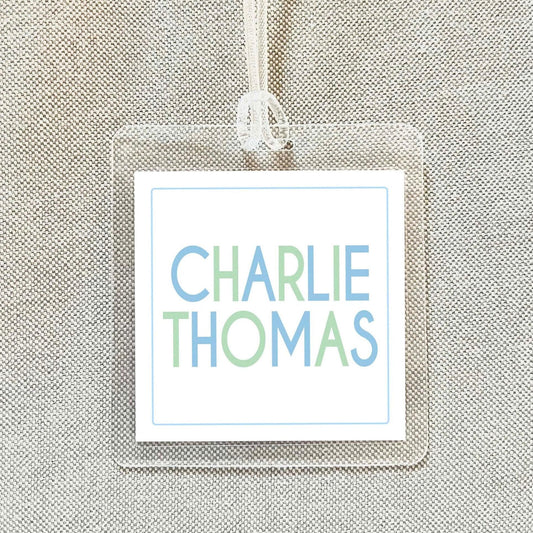 A clear name tag with the name "CHARLIE THOMAS" printed on it.