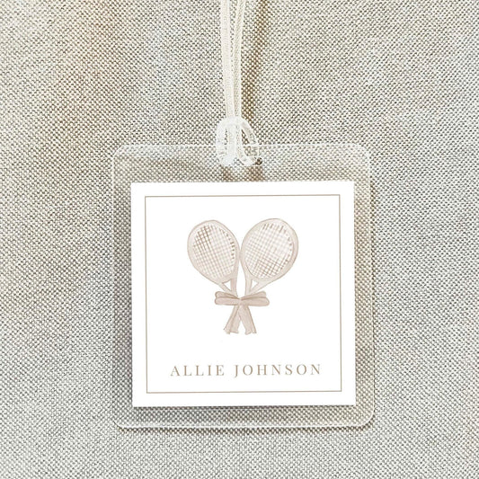 A clear plastic name tag with a tennis racket graphic and the name "Allie Johnson" printed on it.