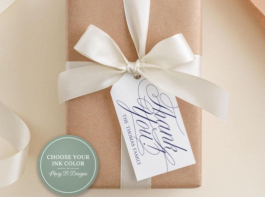 A brown gift box with a white ribbon bow and a white tag attached that says "Thank you The Thomas Family".