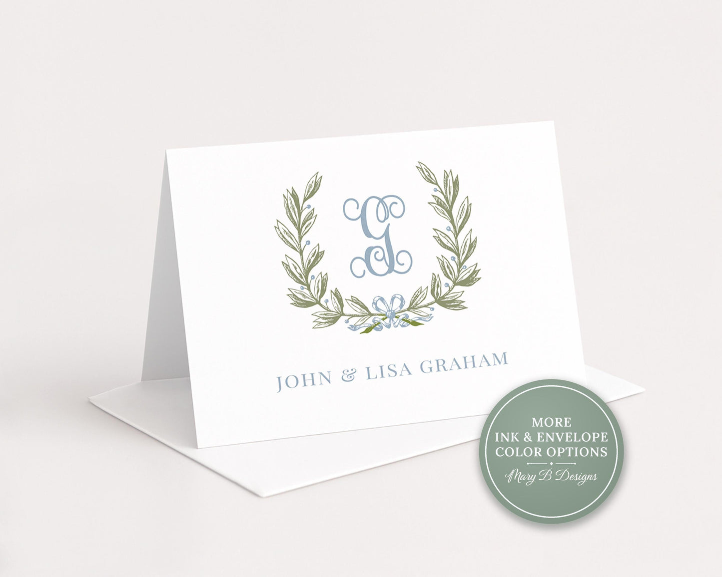 A white greeting card with a monogrammed logo and text, placed on a white surface.