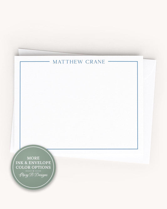 A blank white card with the name 'MATTHEW CRANE' printed on it, placed on top of an envelope.