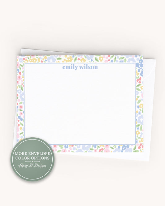 A blank card with a floral border, placed on a plain surface.