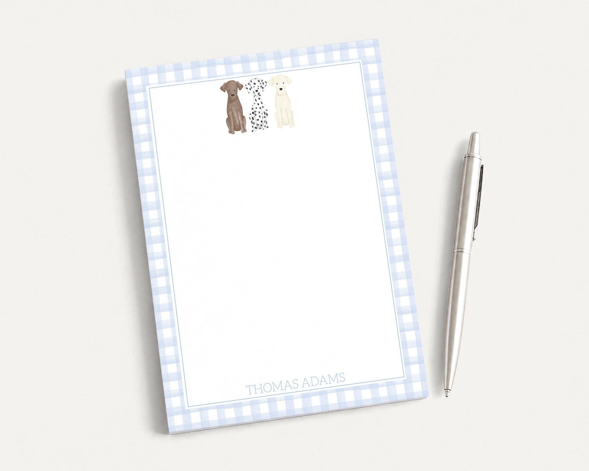 A blue and white checkered notepad with a pen on a white surface.