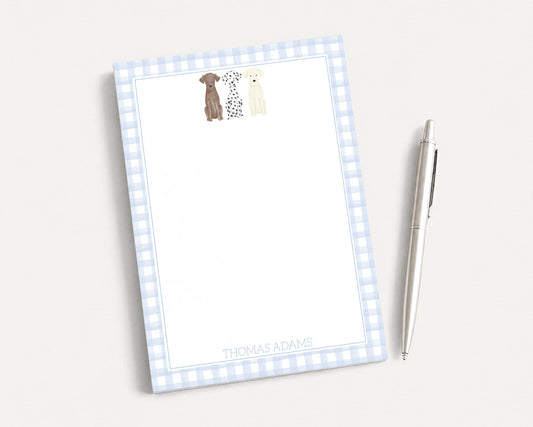 A blue and white checkered notepad with a pen on a white surface.